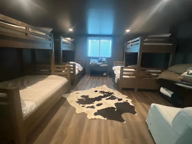 Bunk room with built-in wood bunks and a cowhide rug