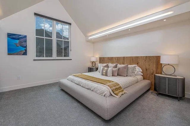 Vaulted master bedroom with a king bed and cove lighting